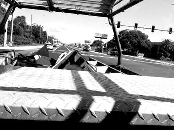 Cars on street against sky on sunny day