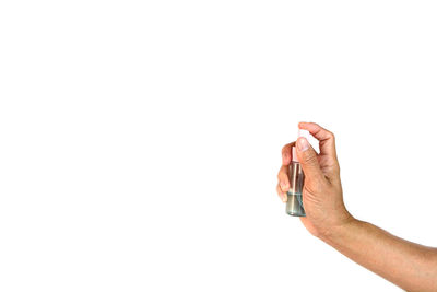 Close-up of hand holding paper over white background