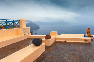 View of coastline from terrace of oia village on a rare rainy day, santorini, greece