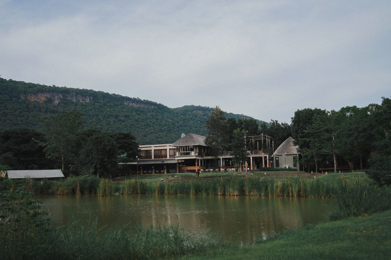 SCENIC VIEW OF LAKE BY HOUSES AGAINST SKY