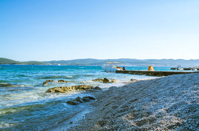 Scenic view of beach against clear blue sky