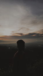 Silhouette man standing on shore against sky during sunset