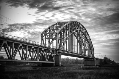 Low angle view of bridge against cloudy sky