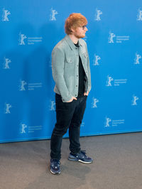 Full length of young man standing against blue sky