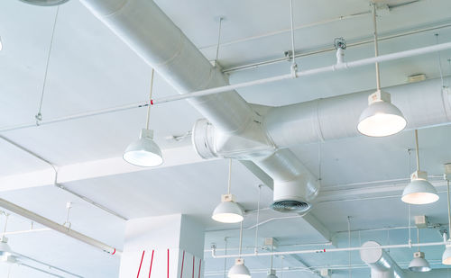 Low angle view of illuminated pendant lights hanging from ceiling