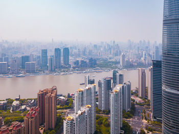 Aerial view of buildings in city against sky