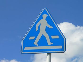 Low angle view of road sign against blue sky