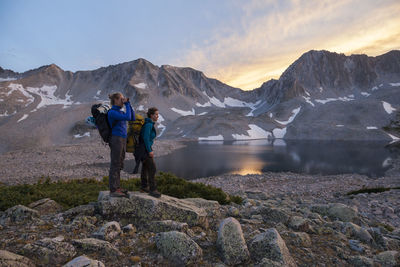 Women hikers watch sunset from pierre lakes, elk mountains, colorado