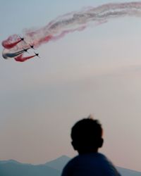 Person paragliding against sky at sunset