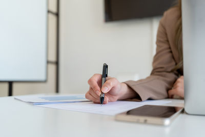 Midsection of businessman working on table