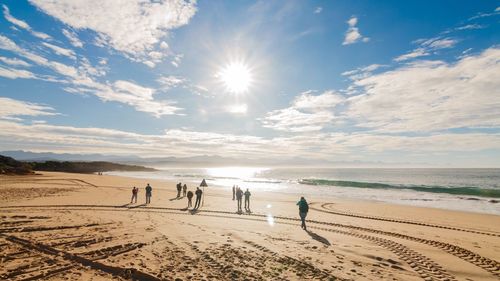 People on beach against sky