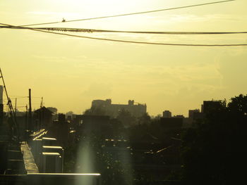 River amidst buildings against sky at sunset