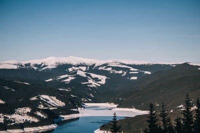 Scenic view of snowcapped mountains against clear sky