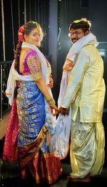 Portrait of standing married couple holding hands toget hindu tradition