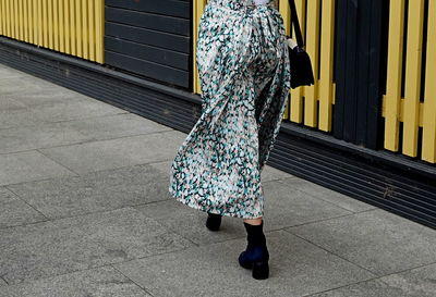 Low section of woman standing on footpath