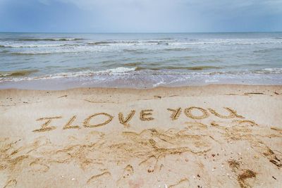 High angle view of i love you message on sandy beach