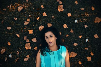 Portrait of beautiful young woman lying down on land
