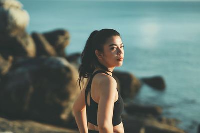 Portrait of young woman sitting at beach