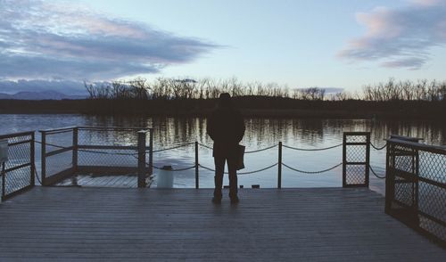 Rear view of man on lake against sky