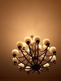 Low angle view of illuminated chandelier hanging from ceiling