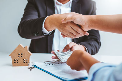 Midsection of man holding hands on table