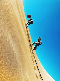 Low angle view of man paragliding against sky