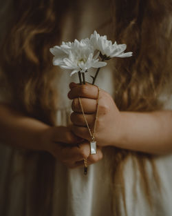 Close-up of woman hand holding flowering plant