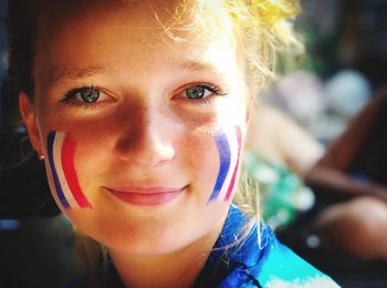 Close-up portrait of girl with french flag face paint