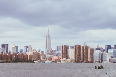 New york buildings in city against cloudy sky