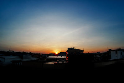 Silhouette cityscape against sky during sunset