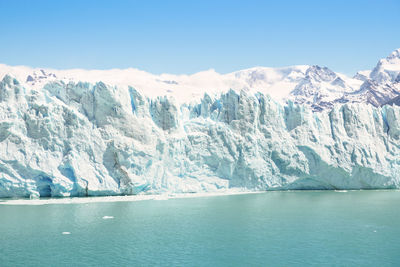 Scenic view of snowcapped mountains by sea against sky