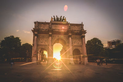 Triumphal arch in city during sunset