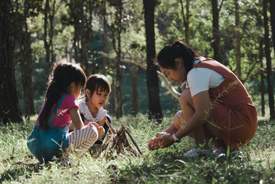 Mother playing with kids in forest