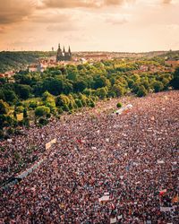 High angle view of crowd on field against sky during sunset