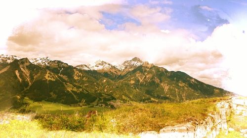 Scenic view of mountains against cloudy sky