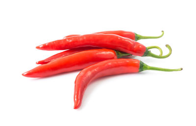 Close-up of red chili peppers over white background