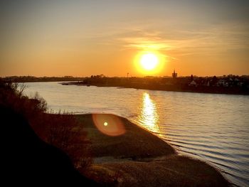 Scenic view of river against sky during sunset