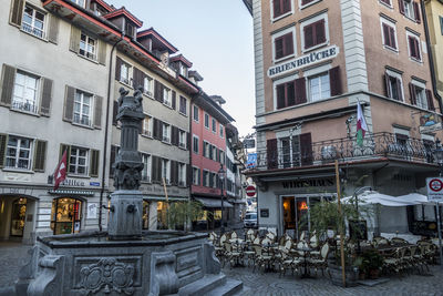 Street by buildings in town against sky