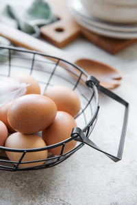 Basket of fresh brown eggs on concrete background