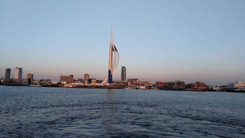 City at waterfront against clear sky