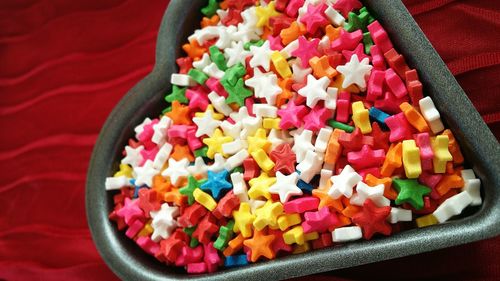 High angle view of colorful candies in heart shape container