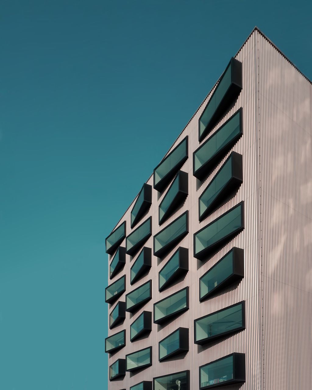 LOW ANGLE VIEW OF BUILDING AGAINST CLEAR BLUE SKY