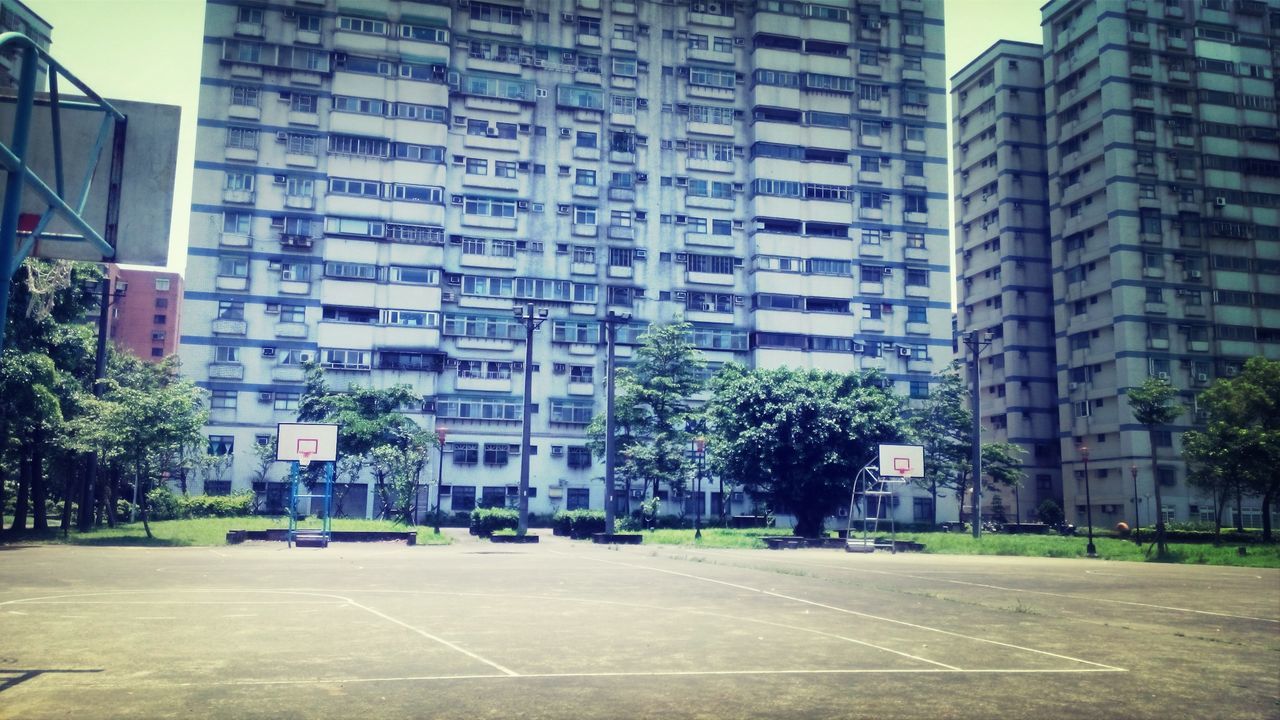 building exterior, architecture, built structure, city, street, the way forward, road, building, transportation, road marking, diminishing perspective, residential building, office building, car, residential structure, city life, day, tree, sky, city street