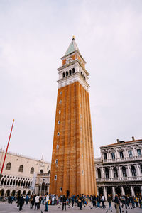 Group of people in front of historical building against sky