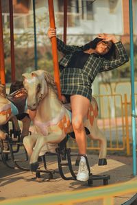 Woman with carousel in amusement park