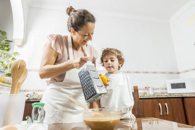 Mother and son preparing food in kitchen