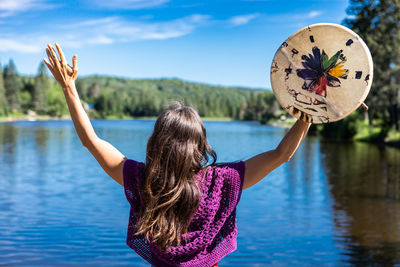 Rear view of woman with umbrella in lake