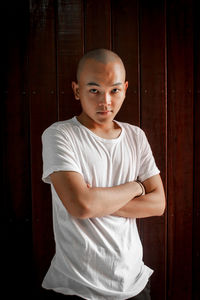 Portrait of teenage boy standing against door