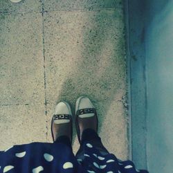 Low section of woman standing on tiled floor