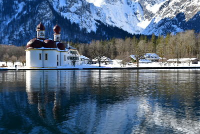 Scenic view of lake by snowcapped mountain against sky